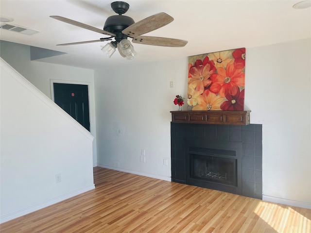 unfurnished living room featuring visible vents, a fireplace, baseboards, and wood finished floors