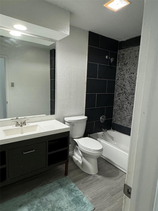 full bathroom featuring visible vents, toilet, shower / washtub combination, vanity, and a textured wall