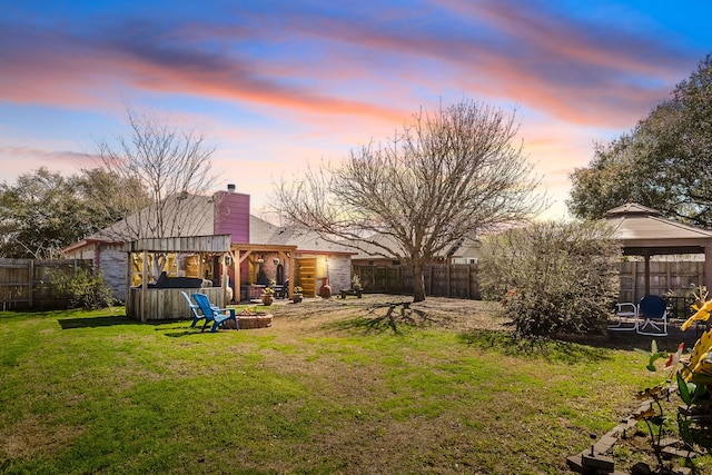 view of yard with a gazebo, a fire pit, and a fenced backyard