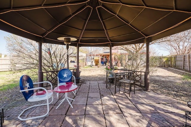 view of patio / terrace featuring a gazebo, outdoor dining area, and a fenced backyard