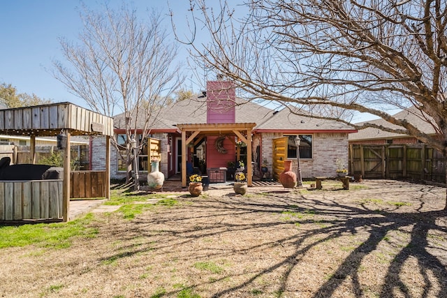 rear view of house featuring a patio area, a chimney, and fence