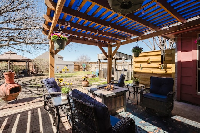 view of patio with a gazebo, an outdoor living space with a fire pit, and fence