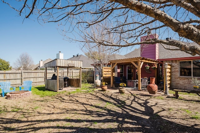 view of yard featuring a pergola, an outdoor fire pit, and fence