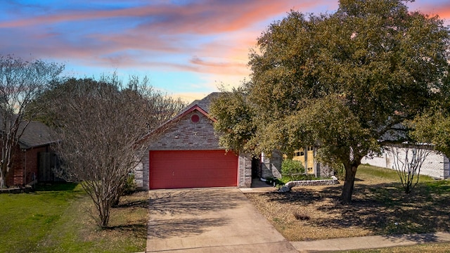 obstructed view of property with brick siding, concrete driveway, a yard, a garage, and stone siding