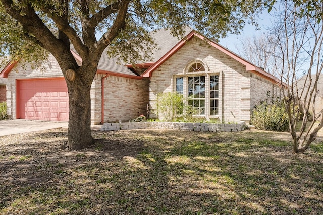 view of front of property featuring brick siding, driveway, and a garage