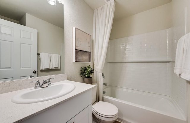 bathroom featuring toilet, vanity, shower / tub combo, and a textured wall