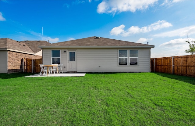 rear view of property featuring a yard, a fenced backyard, and a patio area