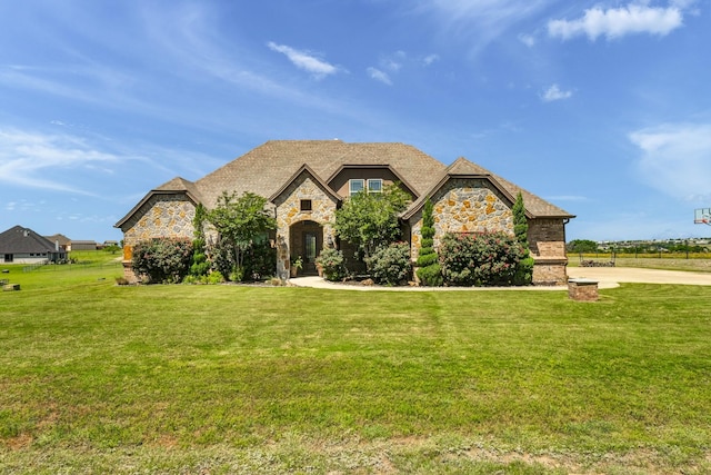 french country inspired facade featuring a front lawn and stone siding