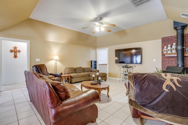 living area featuring vaulted ceiling, a wood stove, and visible vents