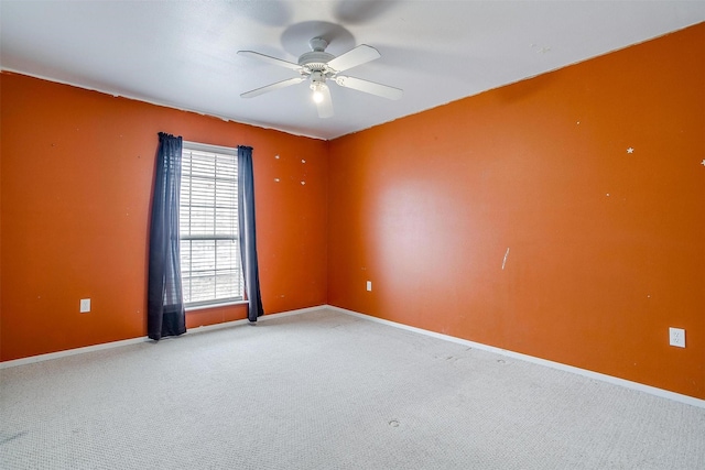 spare room with a ceiling fan, carpet, and baseboards