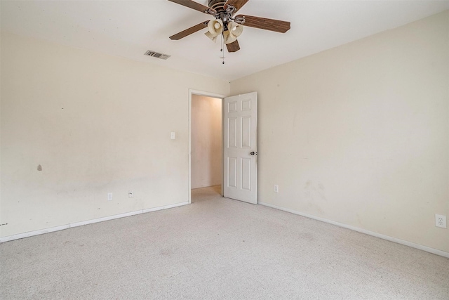 carpeted empty room featuring visible vents, baseboards, and a ceiling fan