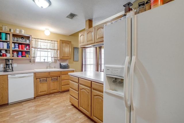 kitchen with visible vents, light wood finished floors, a sink, white appliances, and light countertops