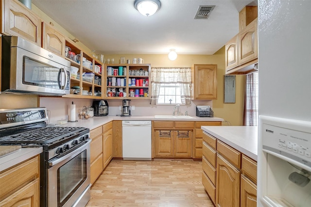 kitchen featuring visible vents, open shelves, a sink, stainless steel appliances, and light countertops