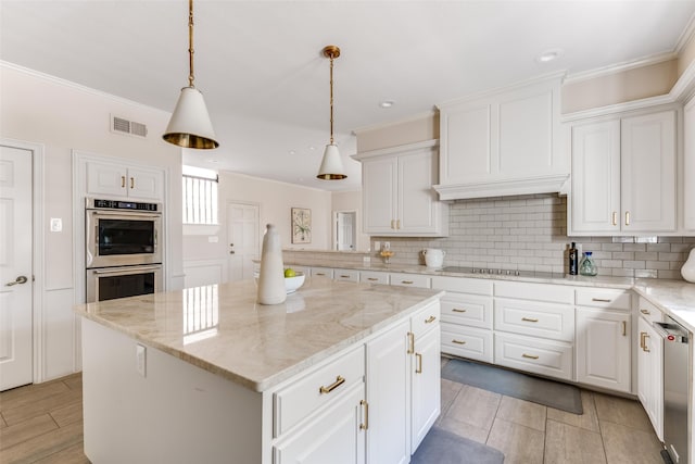 kitchen with tasteful backsplash, visible vents, white cabinets, and stainless steel appliances