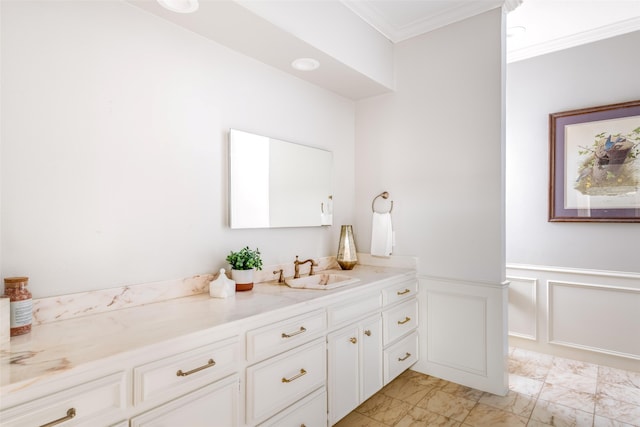 bathroom with crown molding, a wainscoted wall, a decorative wall, marble finish floor, and vanity