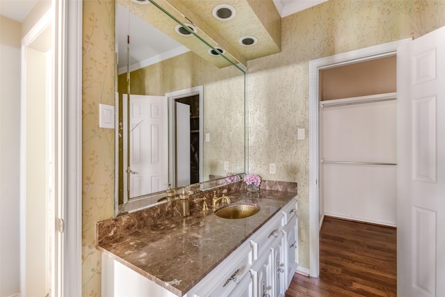 bathroom with wallpapered walls, vanity, and wood finished floors