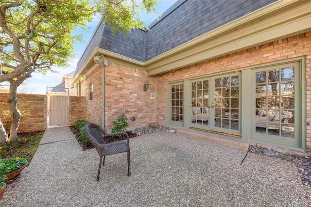 view of patio with a gate, french doors, and fence