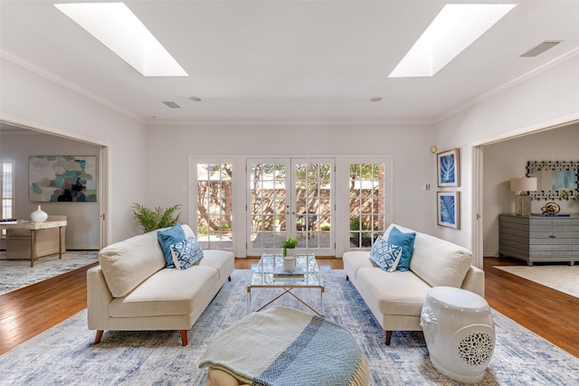 living area featuring visible vents, wood finished floors, and a skylight