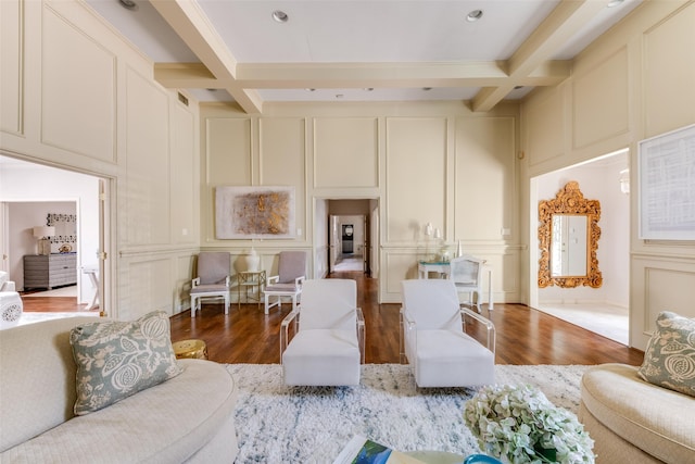 living room featuring a decorative wall, wood finished floors, beamed ceiling, and coffered ceiling