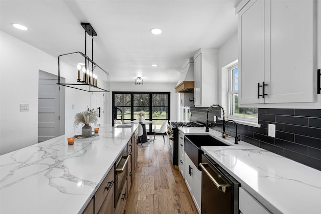 kitchen with dishwashing machine, tasteful backsplash, white cabinets, and light wood finished floors