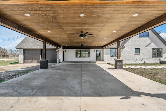 view of patio featuring a garage and a ceiling fan