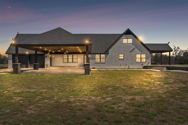 back of house featuring a patio, a yard, a ceiling fan, and a shingled roof