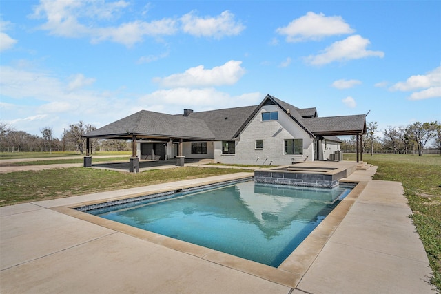 outdoor pool with a yard, a patio, and an in ground hot tub