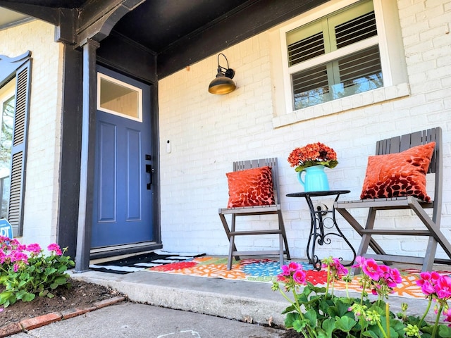 property entrance with brick siding and a porch