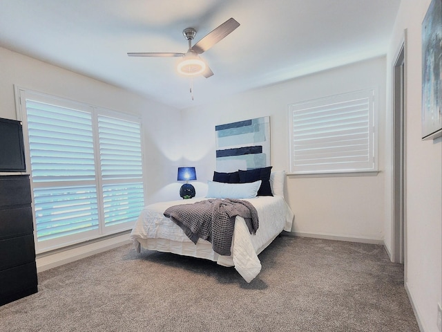 bedroom with ceiling fan, baseboards, and carpet floors