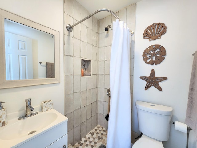 bathroom featuring vanity, a shower stall, and toilet