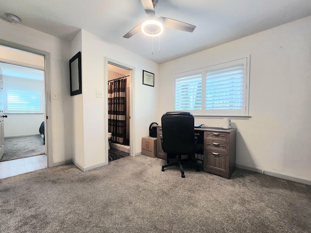 home office featuring light carpet, baseboards, and a ceiling fan