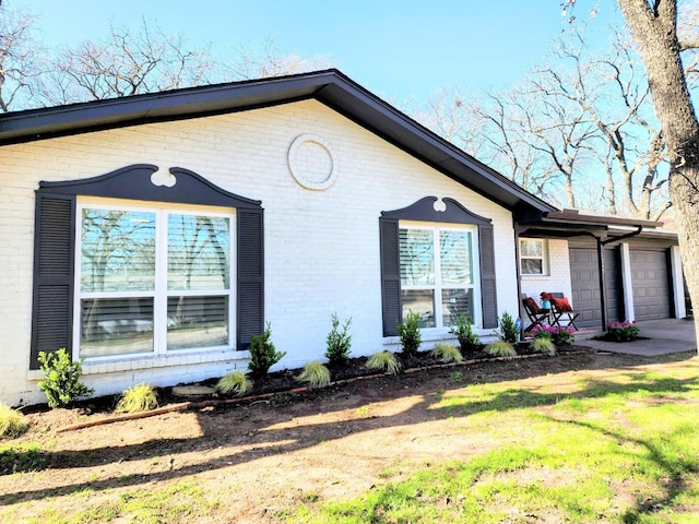 view of front of house featuring brick siding and a garage