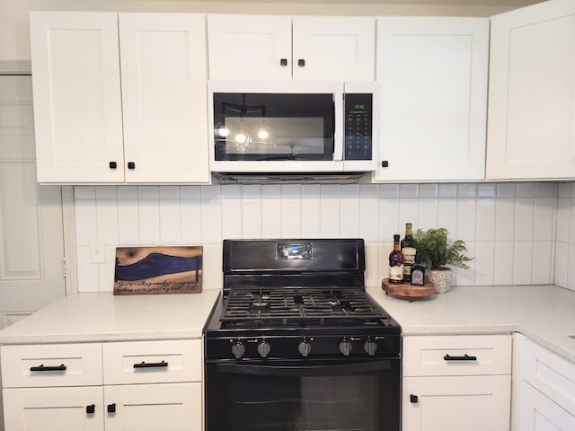 kitchen featuring decorative backsplash, gas stove, white cabinetry, and light countertops