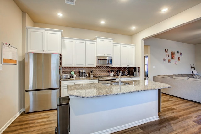 kitchen featuring a sink, light wood-type flooring, appliances with stainless steel finishes, and white cabinets