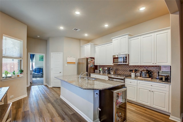 kitchen featuring tasteful backsplash, visible vents, white cabinets, and appliances with stainless steel finishes