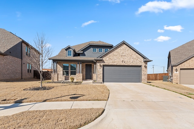 view of front of house featuring brick siding, an attached garage, fence, roof with shingles, and driveway