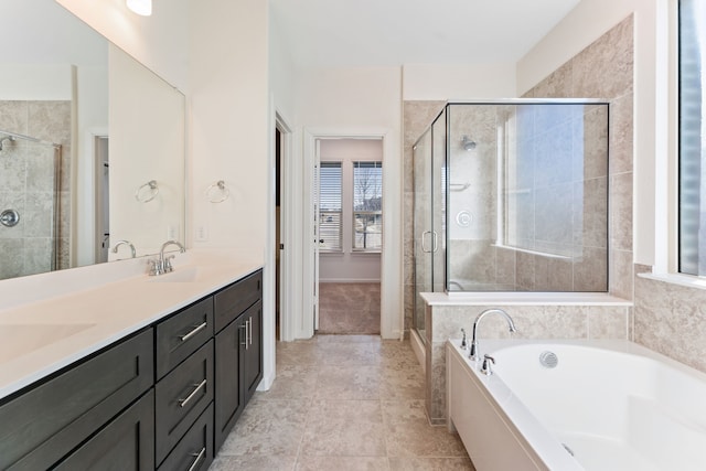 full bath with a sink, a garden tub, double vanity, and a shower stall