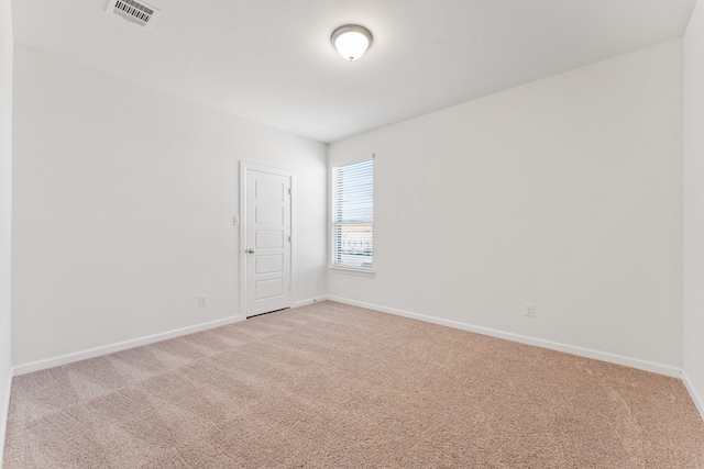 unfurnished room featuring light carpet, visible vents, and baseboards