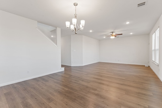 empty room with ceiling fan with notable chandelier, recessed lighting, light wood-style floors, and visible vents