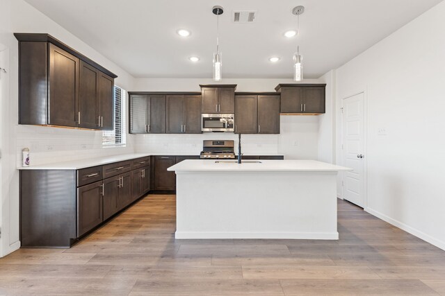 kitchen with visible vents, dark brown cabinets, appliances with stainless steel finishes, and light wood-style flooring