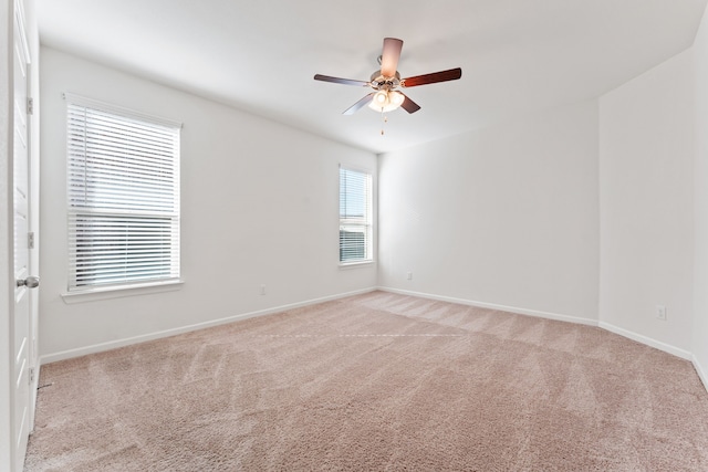 spare room featuring baseboards, light carpet, and ceiling fan