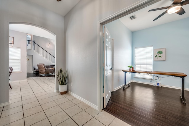 foyer with a ceiling fan, plenty of natural light, arched walkways, and visible vents