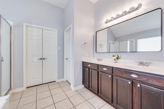 bathroom with tile patterned floors, a stall shower, double vanity, and a sink