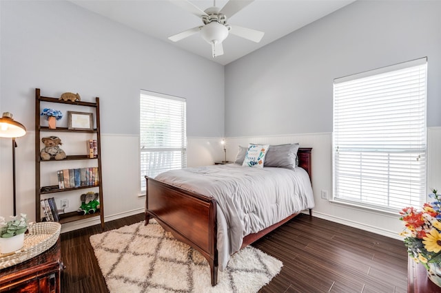 bedroom featuring ceiling fan, baseboards, wood finished floors, and wainscoting