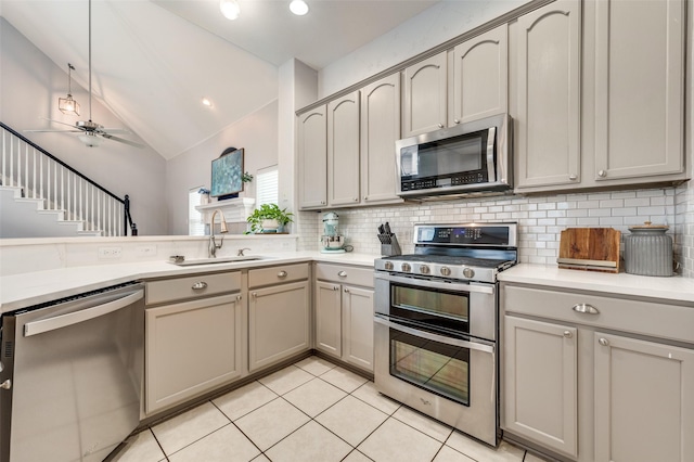 kitchen with a ceiling fan, a sink, tasteful backsplash, stainless steel appliances, and light countertops