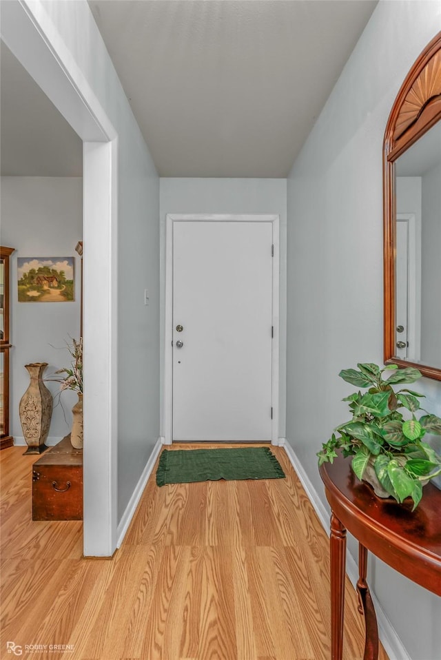 foyer featuring baseboards and wood finished floors