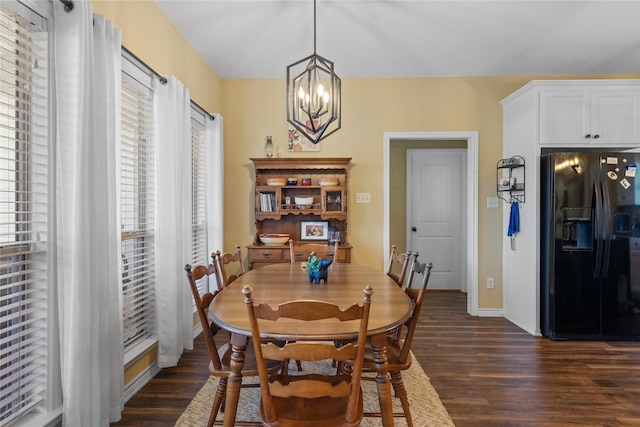 dining space with dark wood finished floors, baseboards, and a chandelier