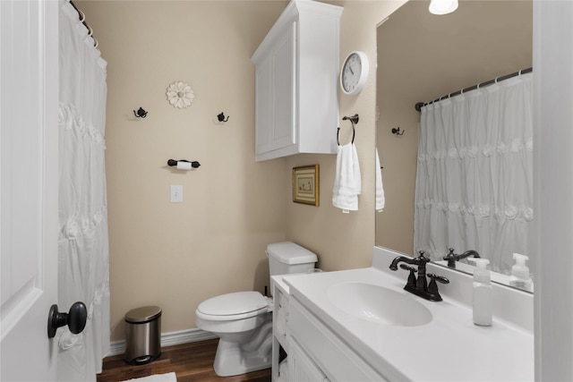 full bath with toilet, vanity, baseboards, and wood finished floors