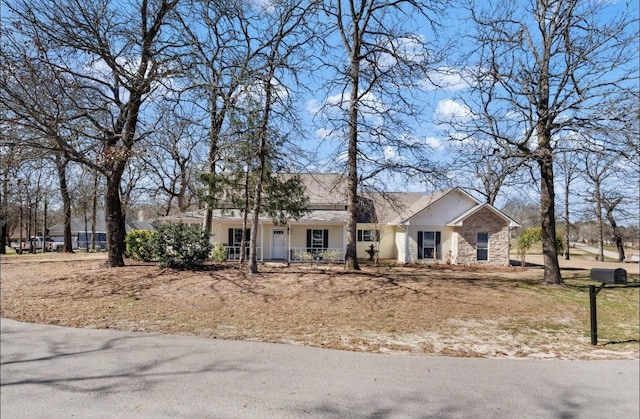 ranch-style house featuring stone siding and covered porch