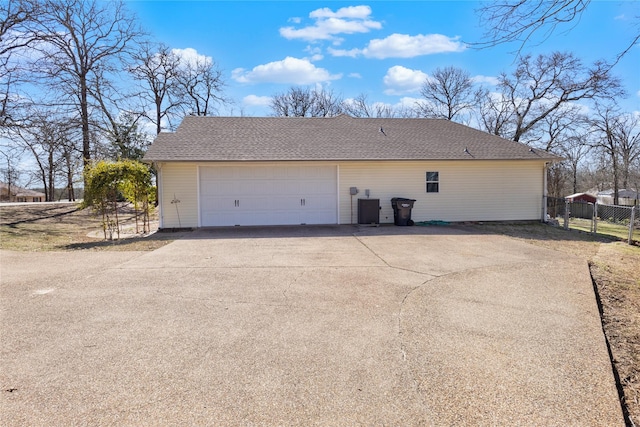 garage with central AC unit and fence